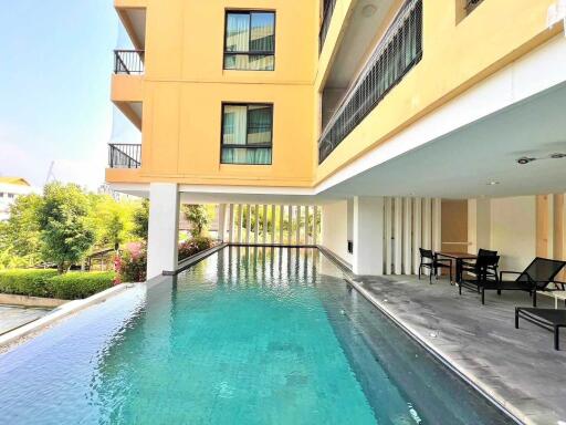 Outdoor swimming pool next to building with balcony view