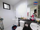 Bathroom with white tiles, glass window, and toiletries on the countertop