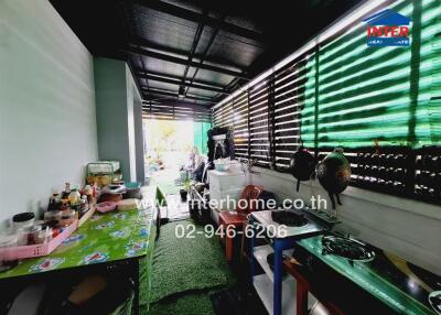 Covered outdoor kitchen area with various kitchen appliances and utensils.