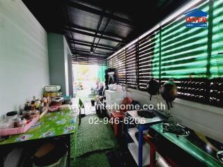 Covered outdoor kitchen area with various kitchen appliances and utensils.