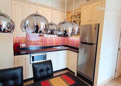 Modern kitchen with stylish hanging lights and vibrant backsplash.