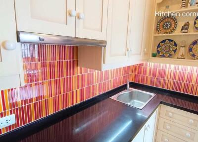 Modern kitchen with colorful backsplash and decorative shelves