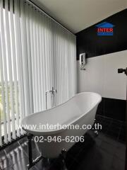 Contemporary bathroom with freestanding bathtub and large windows with vertical blinds