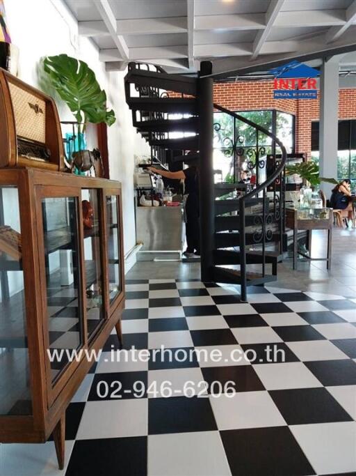 Spiral staircase in a checkerboard-floored room with a glass cabinet and decorative items