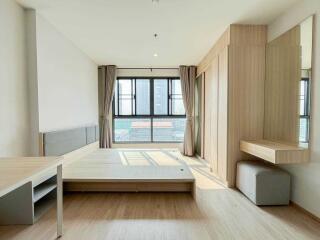 Modern bedroom with large window and built-in furniture