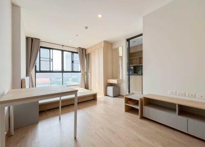 Spacious living area with large window, natural light, and modern furniture