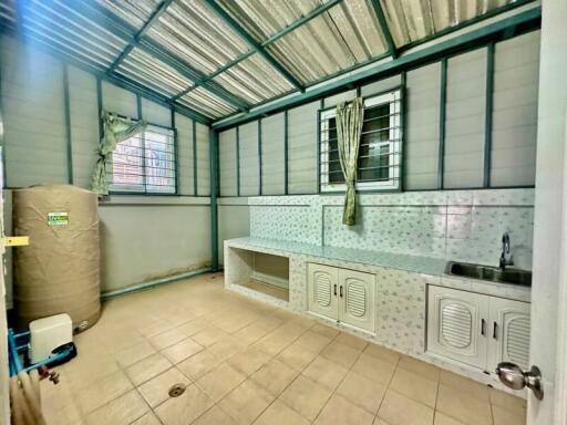 Well-lit utility room with storage and washing area