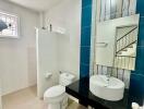 Modern bathroom with a large mirror, sink, toilet, and decorative tiles