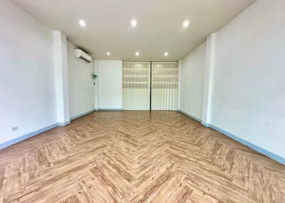 Spacious and well-lit living room with wooden flooring and air conditioning