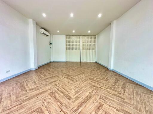 Spacious and well-lit living room with wooden flooring and air conditioning