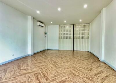 Spacious living room with wooden flooring and white walls