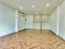 Spacious living room with wooden flooring and white walls