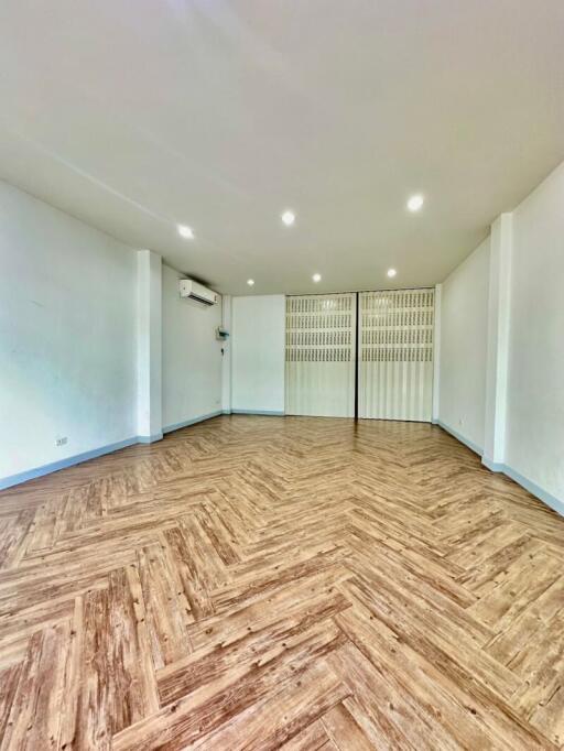 Spacious living room with wooden flooring and white walls