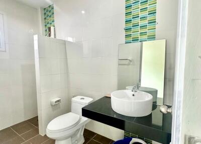 Modern bathroom with sink, toilet, and tiled walls