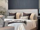 Modern bedroom with grey headboard and pillows, accent wall, and decorative plants