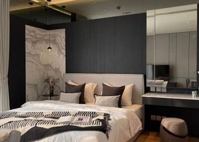 Modern bedroom with decorative wall panels, a large bed, and a vanity area