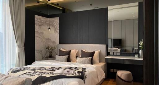Modern bedroom with decorative wall panels, a large bed, and a vanity area