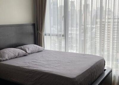 Bedroom with a view of the cityscape through large windows