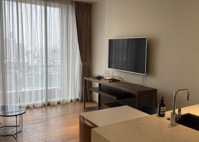 Modern living room with large window, TV, and kitchen counter