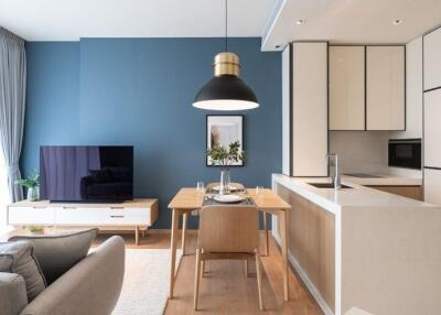 Modern living room and kitchen with blue accent wall and stylish furniture