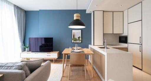 Modern living room and kitchen with blue accent wall and stylish furniture