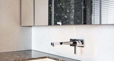 Modern bathroom sink with marble countertop and wall-mounted faucet