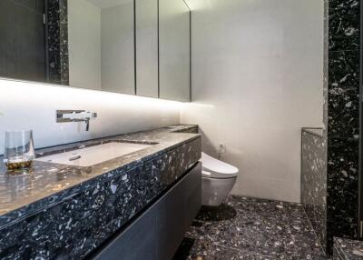 Modern bathroom with marble countertop and under-cabinet lighting