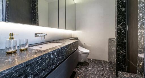 Modern bathroom with marble countertop and under-cabinet lighting