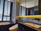 Modern bathroom with city view, bathtub, and black marble finishes