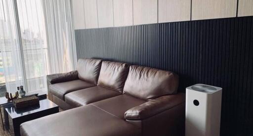 Modern living room with brown leather sectional sofa and air purifier