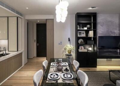 Modern dining area with table set for meal, and living room in the background