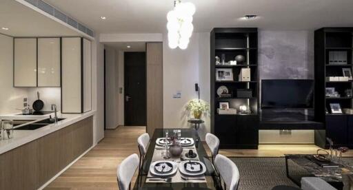 Modern dining area with table set for meal, and living room in the background