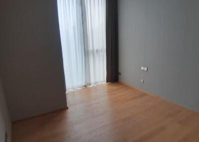 Empty bedroom with wooden floor and curtains on large window