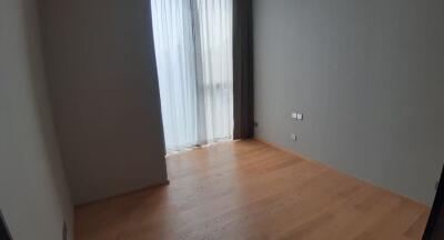 Empty bedroom with wooden floor and curtains on large window