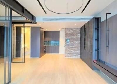 Modern living room with glass doors, brick accent wall, and built-in shelving