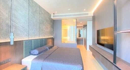 Modern spacious bedroom with a large bed, wall-mounted TV, and en-suite bathroom