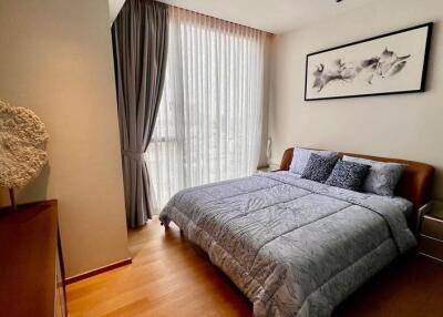 Bedroom with a large window, curtains, double bed, and a framed picture