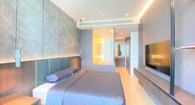 Modern bedroom with mounted TV and ensuite bathroom