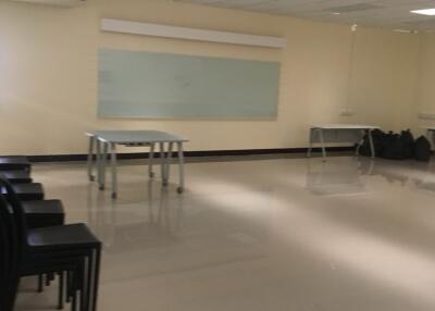 Spacious multipurpose room with modern lighting and whiteboard