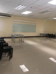 Spacious multipurpose room with modern lighting and whiteboard