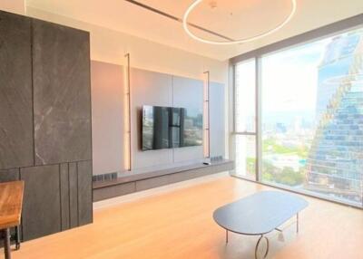 Modern living room with city view featuring a large window, mounted TV, and minimalist furniture