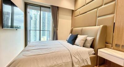 Modern bedroom with a large window, stylish headboard, and a view of city high-rises