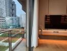 Modern living room with large flat-screen TV and city view balcony