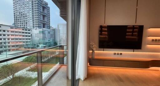 Modern living room with large flat-screen TV and city view balcony