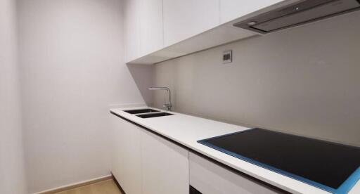 Modern minimalist kitchen with white cabinetry and countertop