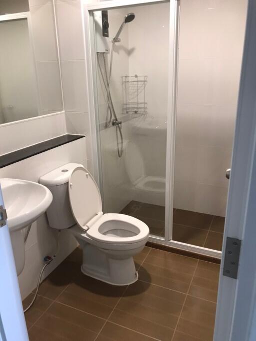 Modern bathroom with glass shower enclosure, toilet, and sink