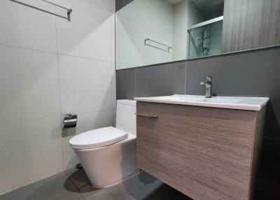 Modern bathroom with vanity, toilet, and mirror