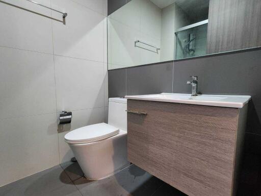 Modern bathroom with vanity, toilet, and mirror