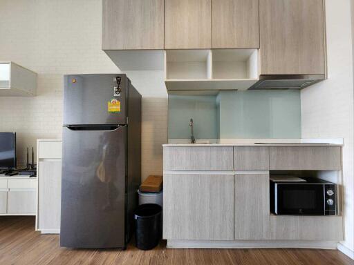 Modern kitchen with stainless steel refrigerator and built-in microwave