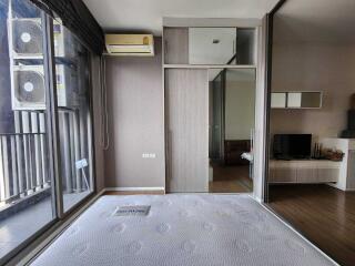 Bedroom with large windows, air conditioner, and adjacent living space